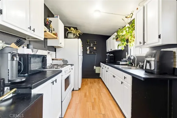 a kitchen with stainless steel appliances granite countertop a sink a stove and a refrigerator