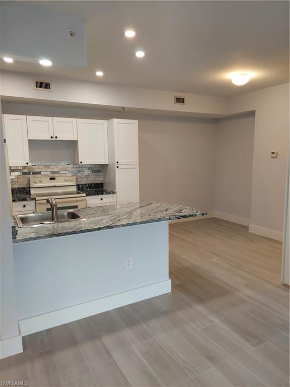 6341 Aragon Way, Unit 106 Fort Myers, FL 33966 - Photo 8 of 29 a large kitchen with stainless steel appliances granite countertop a stove a sink and a refrigerator