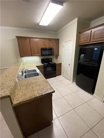 a kitchen with kitchen island granite countertop a sink stove and refrigerator