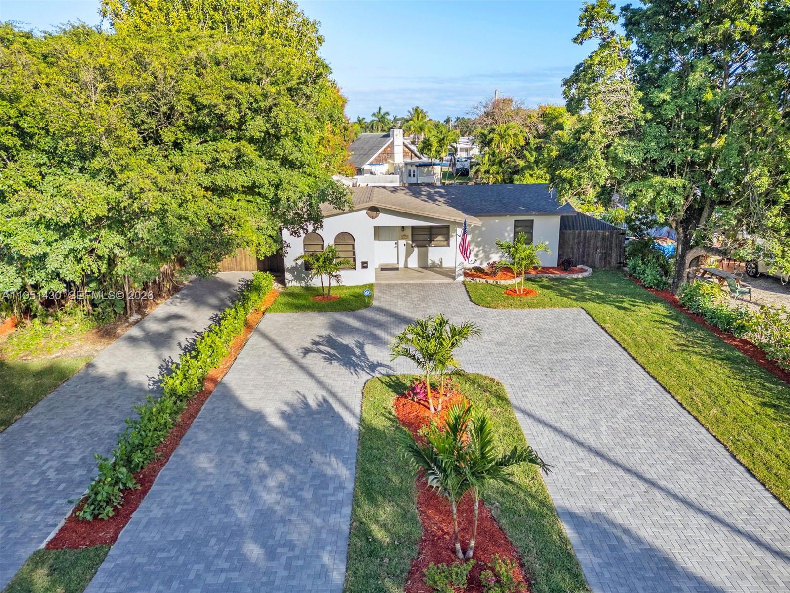 1075 Northeast 12th Avenue, Unit 1075 Homestead, FL 33033 - Photo 1 of 49 a front view of a house with swimming pool lawn chairs and a fire pit