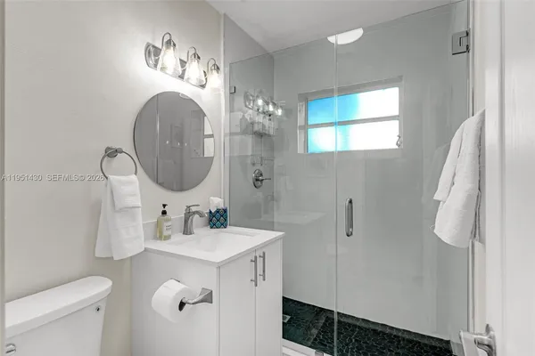 a bathroom with a sink mirror and toilet