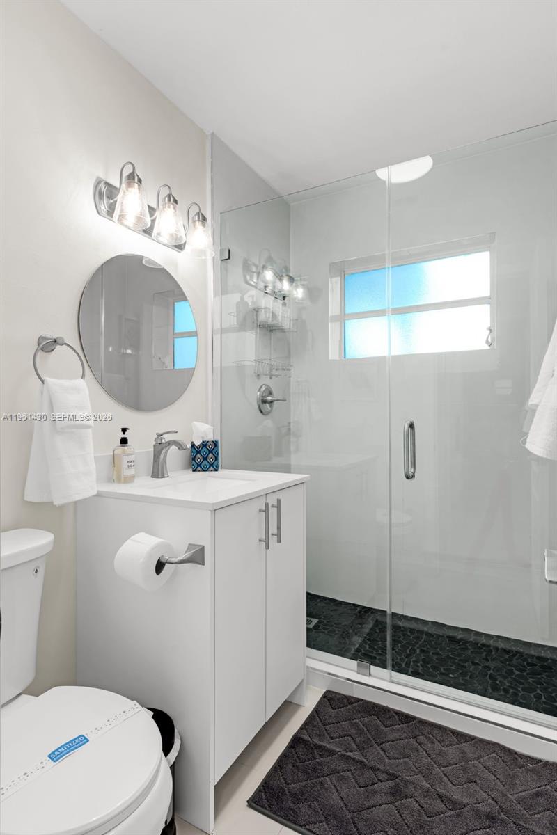 1075 Northeast 12th Avenue, Unit 1075 Homestead, FL 33033 - Photo 18 of 49 a bathroom with a sink mirror and toilet