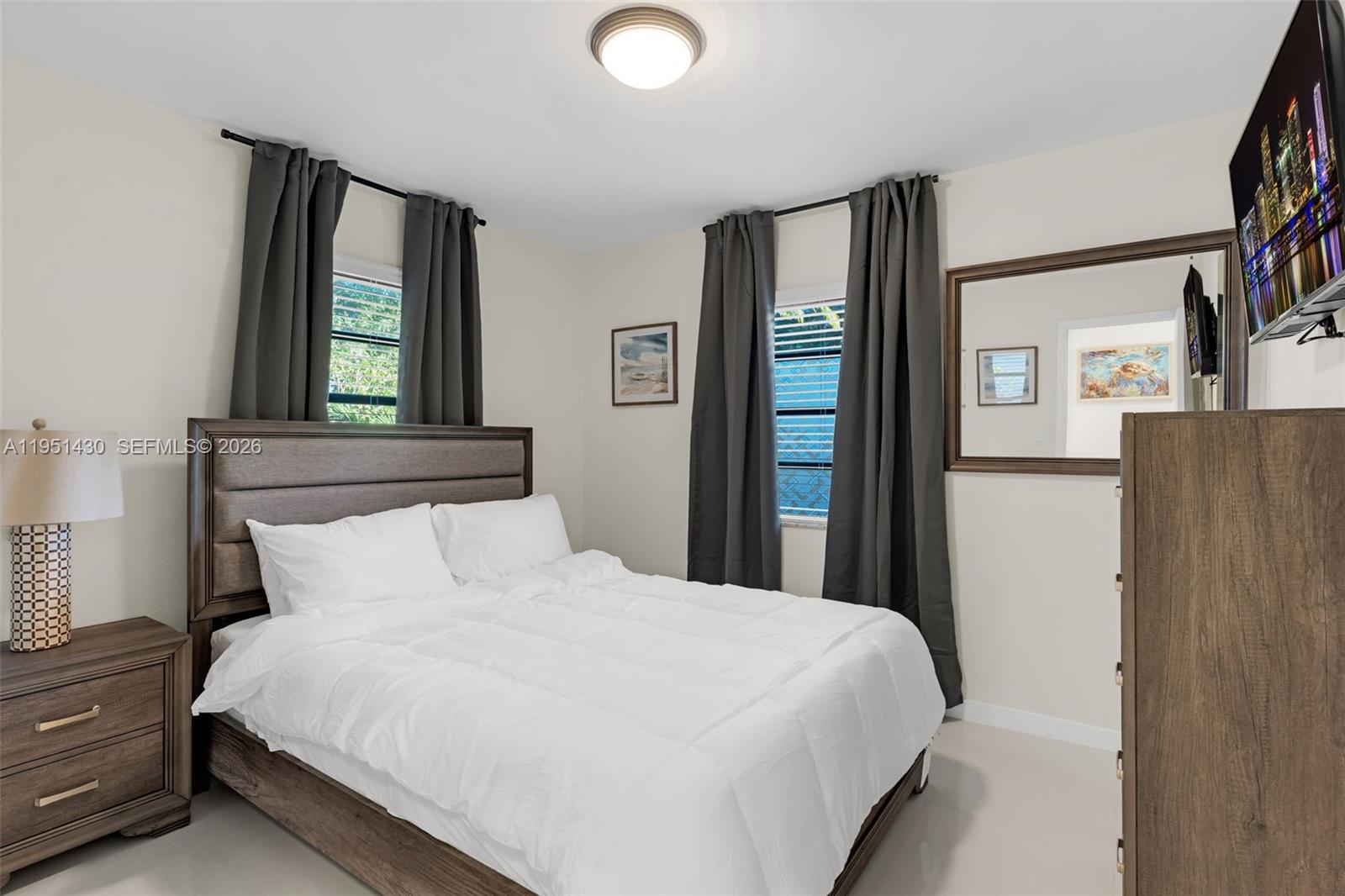 1075 Northeast 12th Avenue, Unit 1075 Homestead, FL 33033 - Photo 19 of 49 a bedroom with a large bed and a window