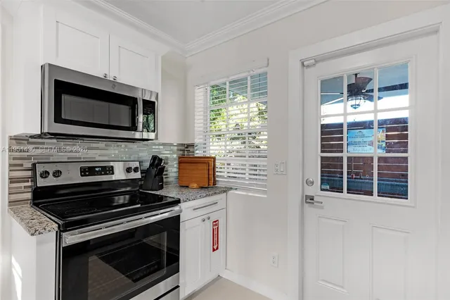 a kitchen with cabinets stainless steel appliances and a window