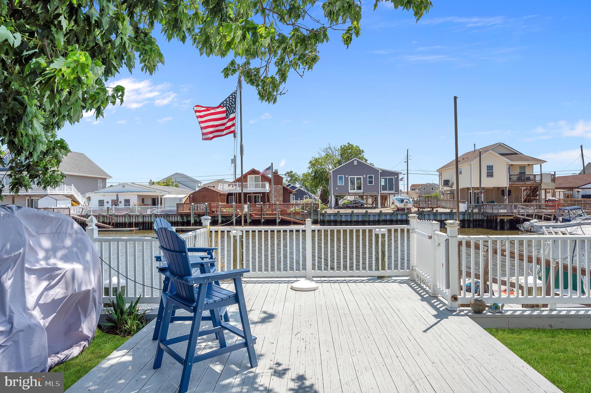 25 West Dory Drive Little Egg Harbor, NJ 08087 - Photo 27 of 56 a view of a roof deck with table and chairs a barbeque with wooden fence