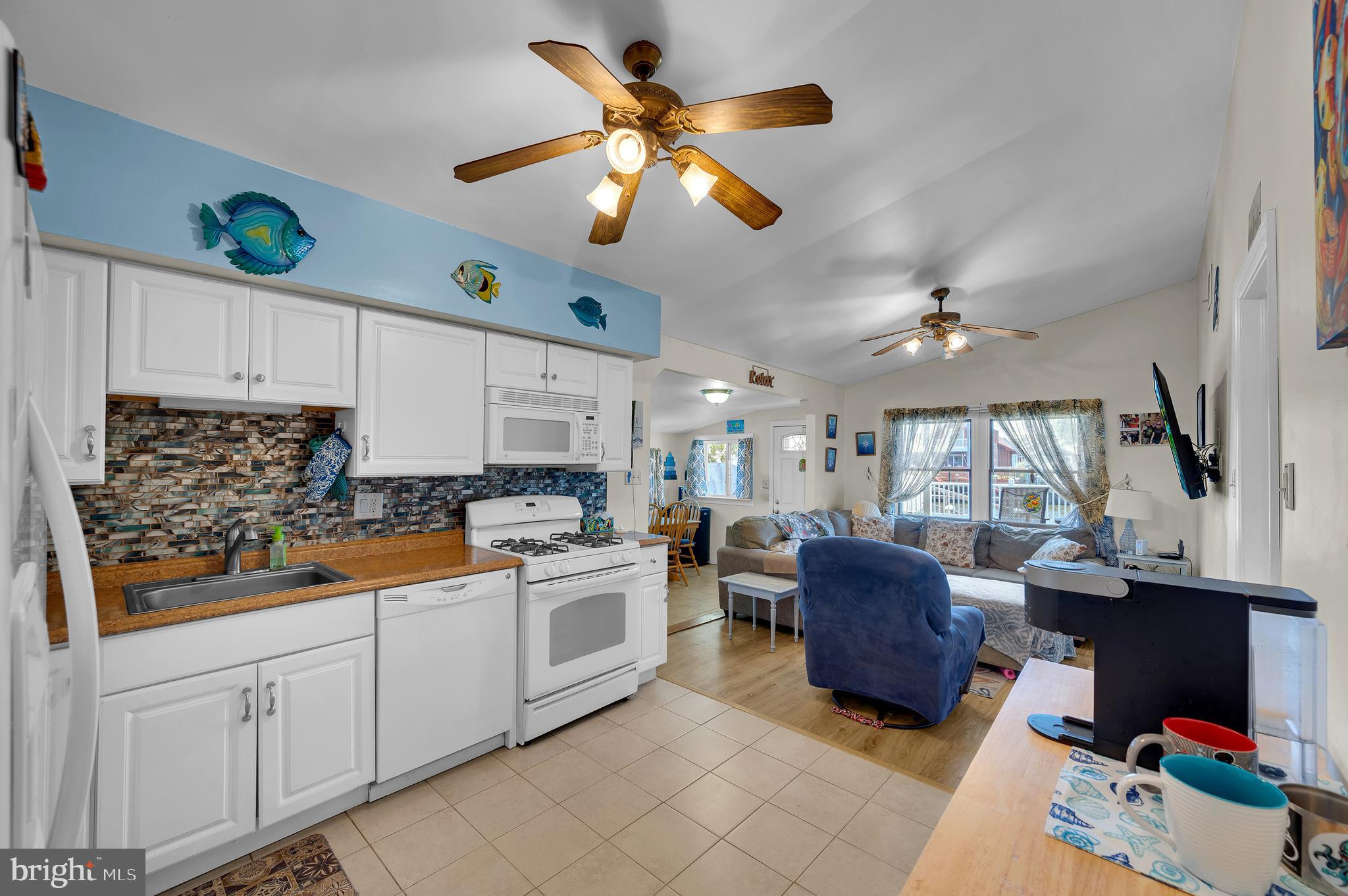 25 West Dory Drive Little Egg Harbor, NJ 08087 - Photo 45 of 56 a kitchen with stainless steel appliances granite countertop a refrigerator a stove a sink dishwasher and white cabinets with wooden floor