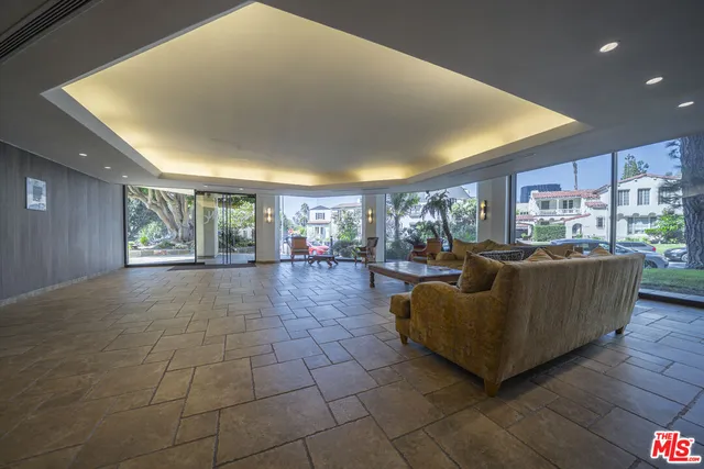 a living room with couches and kitchen view with wooden floor