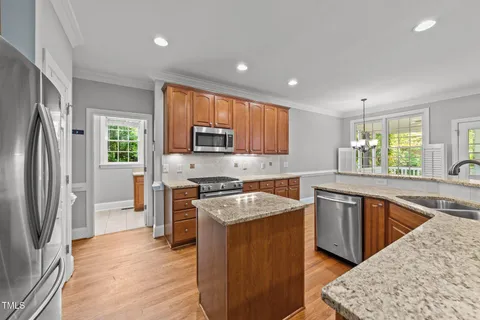 a kitchen with stainless steel appliances granite countertop a refrigerator a stove top oven a sink and dishwasher