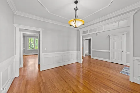 a view of an empty room with wooden floor and window