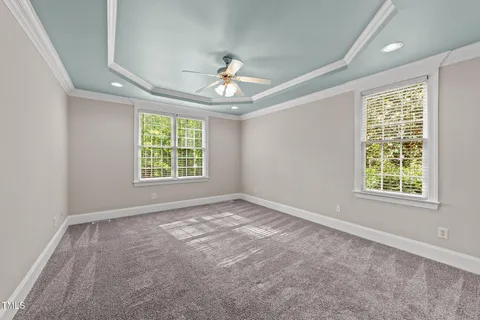 an empty room with windows and chandelier fan