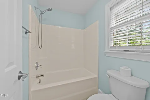 a bathroom with a toilet and a bath tub