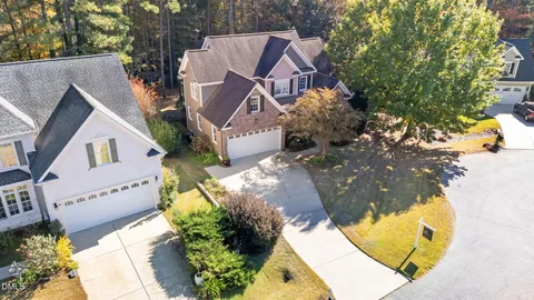 an aerial view of a house with swimming pool and large trees