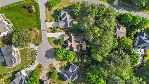 an aerial view of residential house with outdoor space and trees all around