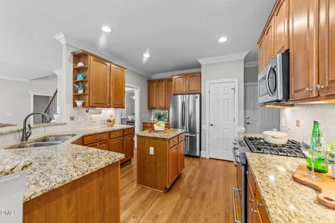 a kitchen with stainless steel appliances granite countertop a sink stove and refrigerator