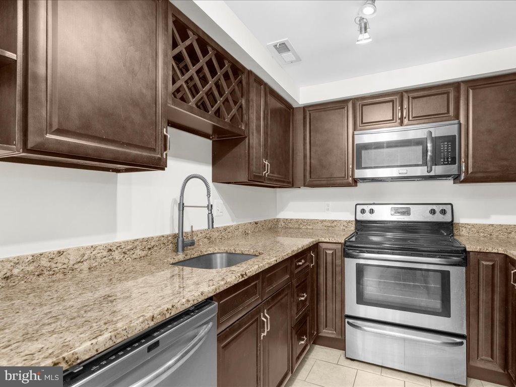 723 South Charles Street, Unit 306 Baltimore, MD 21230 - Photo 7 of 23 a kitchen with granite countertop a stove and a sink