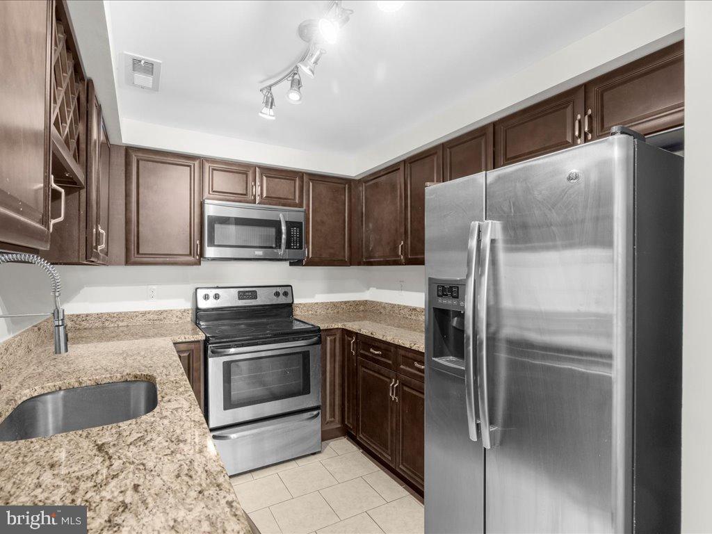723 South Charles Street, Unit 306 Baltimore, MD 21230 - Photo 8 of 23 a kitchen with granite countertop a refrigerator and a sink