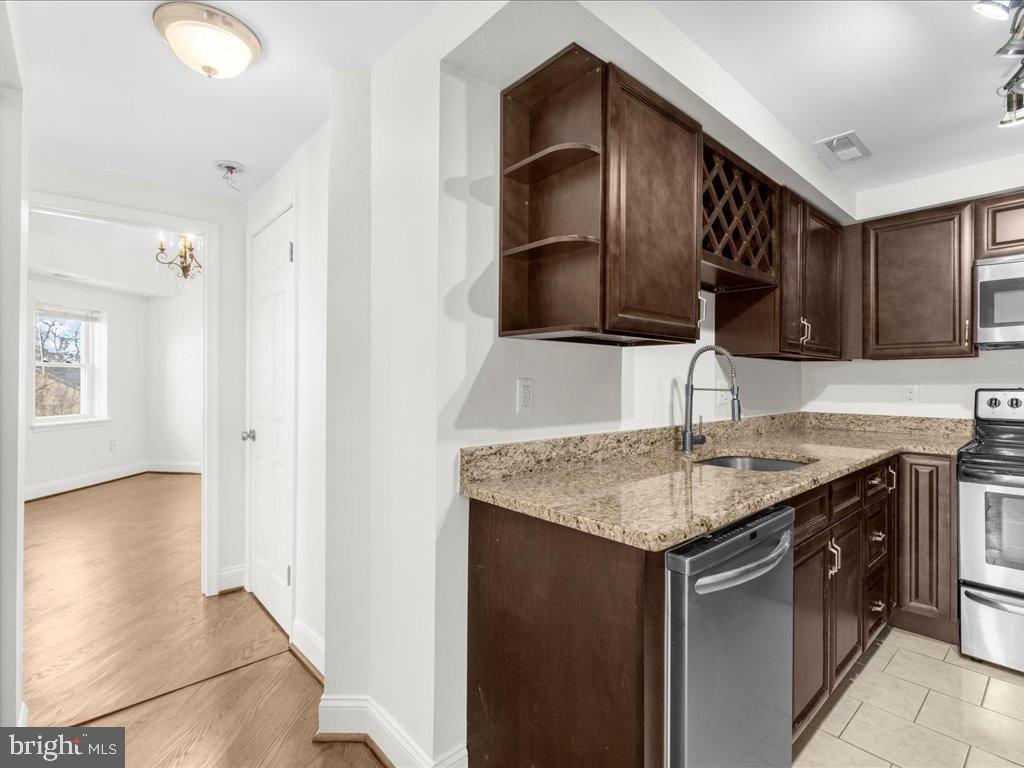 723 South Charles Street, Unit 306 Baltimore, MD 21230 - Photo 9 of 23 a kitchen with stainless steel appliances granite countertop a sink and a refrigerator