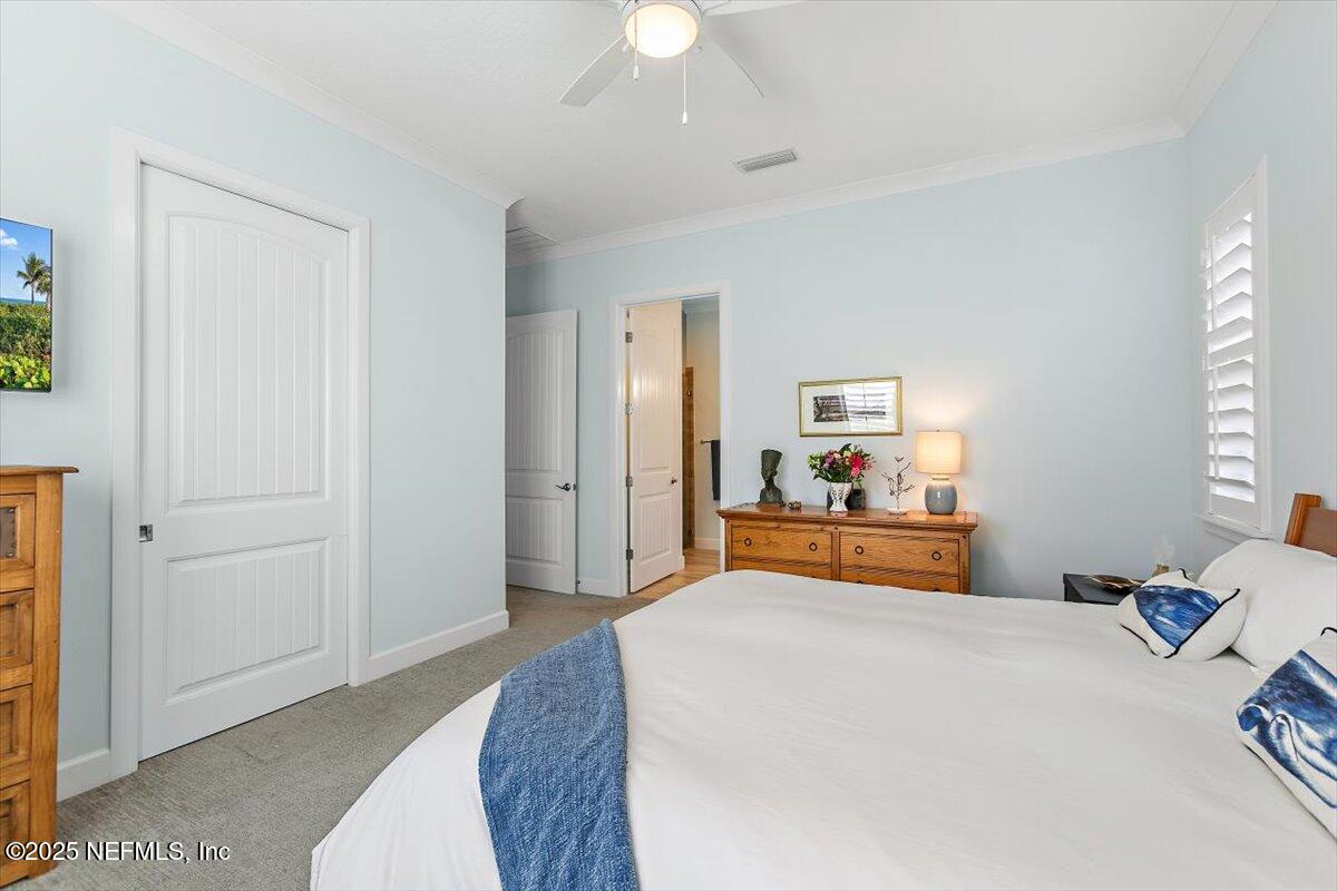 175 Oceanview Drive St. Augustine, FL 32080 - Photo 18 of 56 a bedroom with a bed and a chandelier