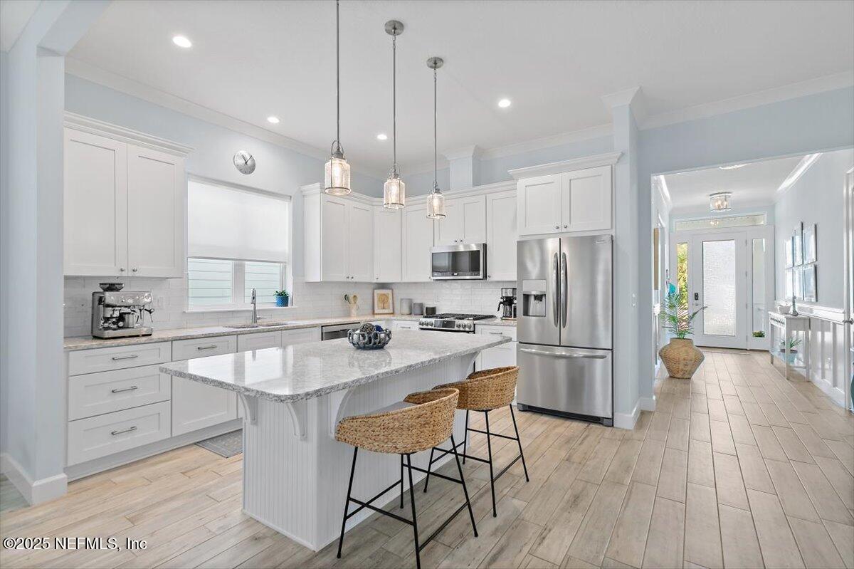 175 Oceanview Drive St. Augustine, FL 32080 - Photo 6 of 56 a kitchen with stainless steel appliances kitchen island granite countertop a table chairs refrigerator and microwave