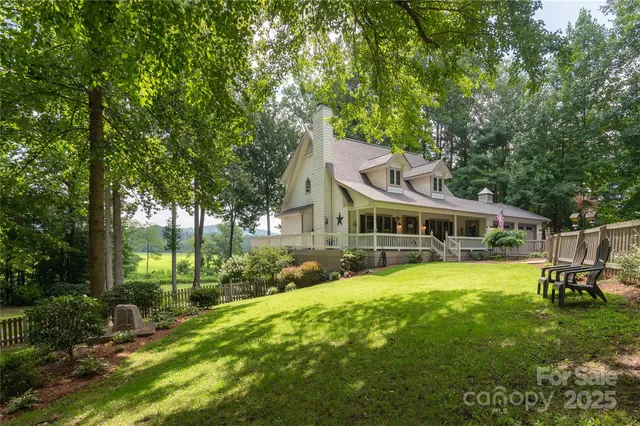 a view of a house with a big yard and large trees