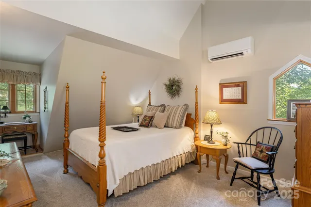 a bedroom with a bed a couch and dresser with wooden floor