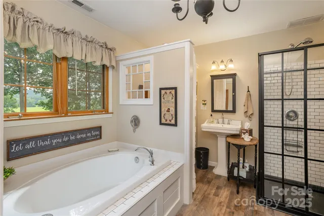 a bathroom with a tub a sink and a window