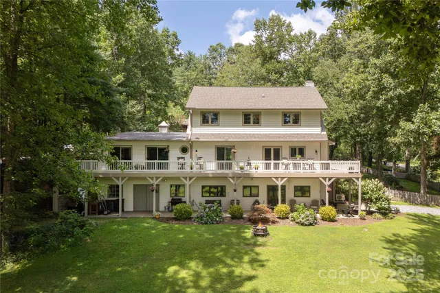 a view of a house with a big yard and large trees