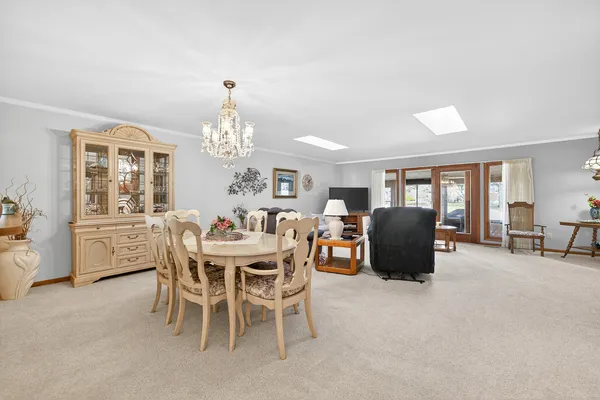 a dining room with furniture a chandelier and window