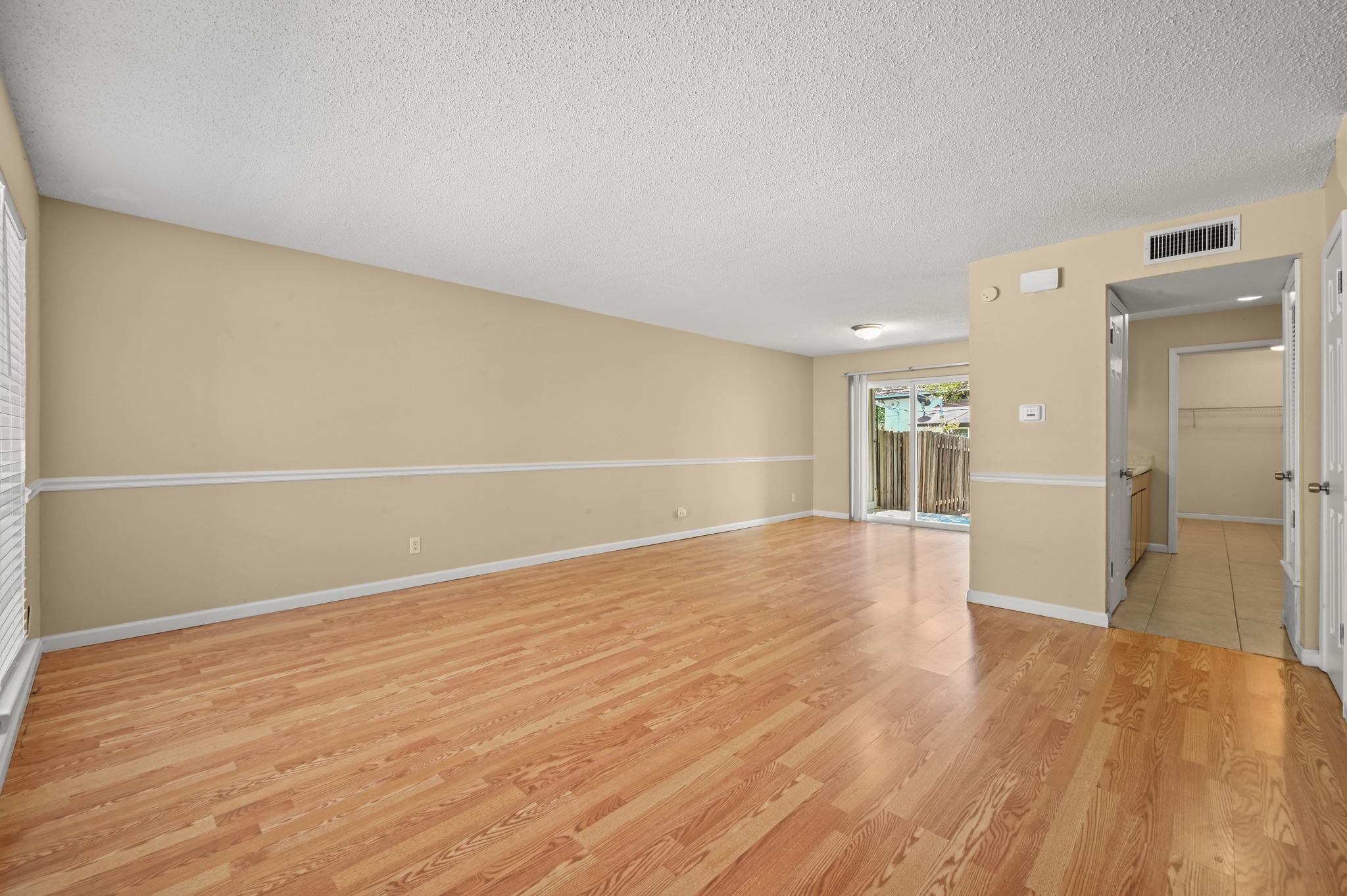 Gleaming wood floors and a sliding glass door define this versatile open living space.