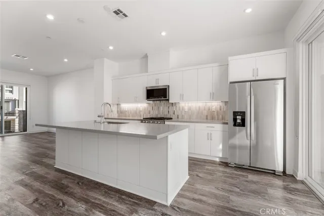 a kitchen with stainless steel appliances a sink stove and cabinets