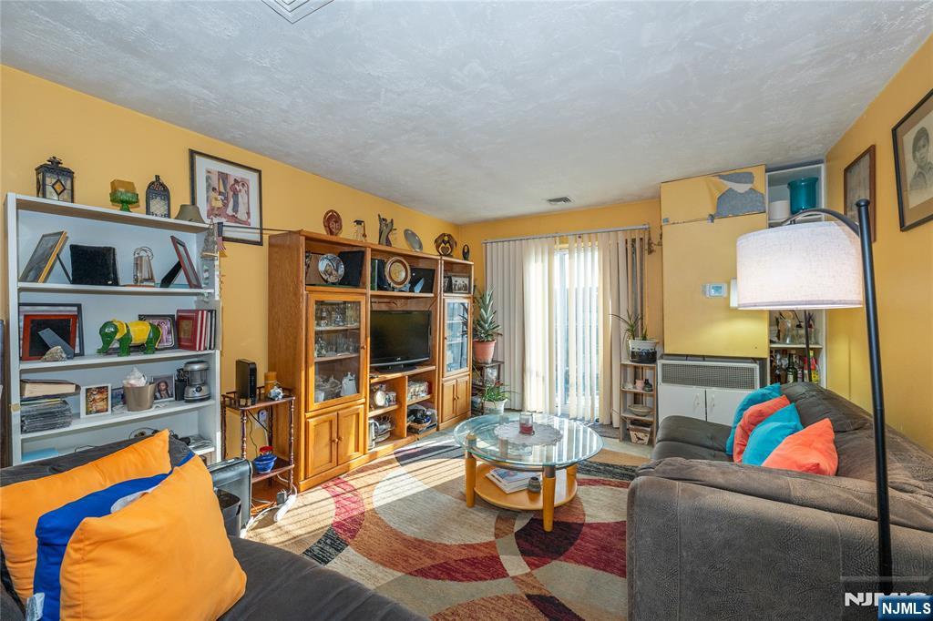 75 Union Street, Unit 5E Hackensack, NJ 07601 - Photo 12 of 24 a living room with furniture a rug and a flat screen tv