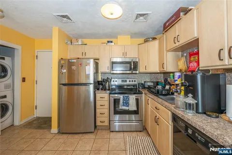 a kitchen with stainless steel appliances granite countertop a refrigerator stove and sink