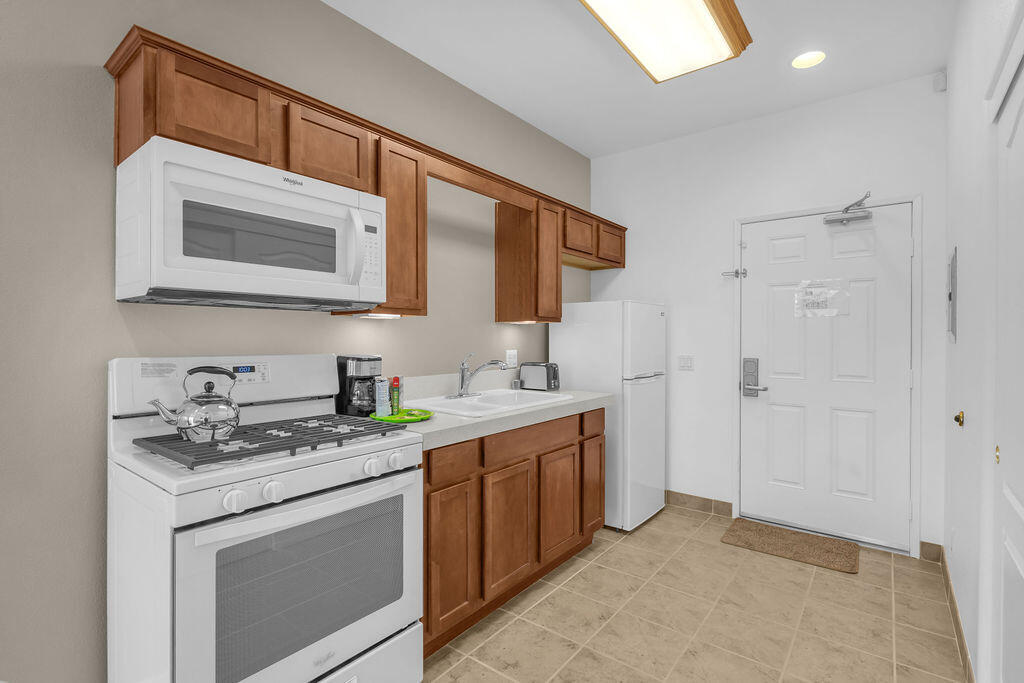 12622 Miracle Hill Road Desert Hot Springs, CA 92240 - Photo 110 of 124 a kitchen with stainless steel appliances granite countertop a sink stove and cabinets