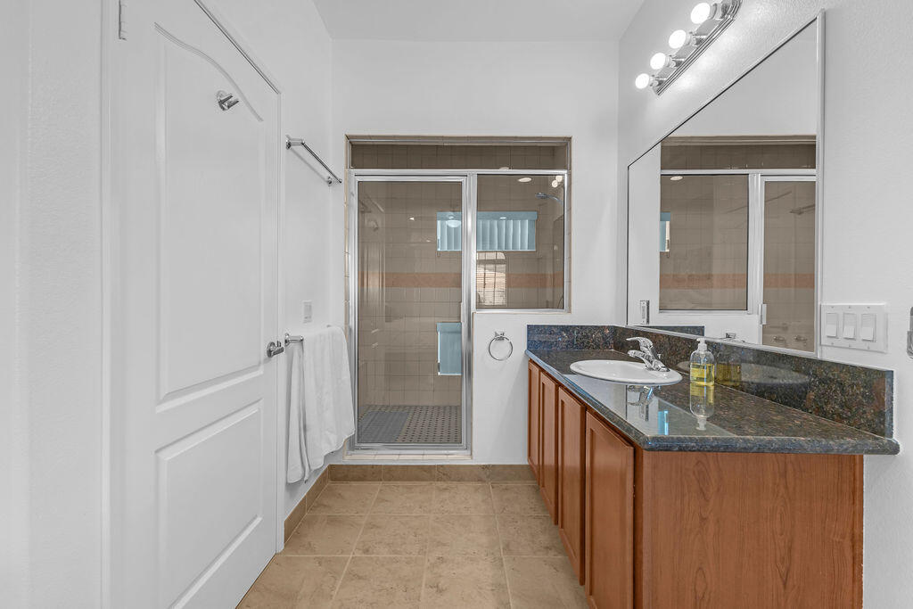 12622 Miracle Hill Road Desert Hot Springs, CA 92240 - Photo 124 of 124 a bathroom with a granite countertop sink a mirror and a shower