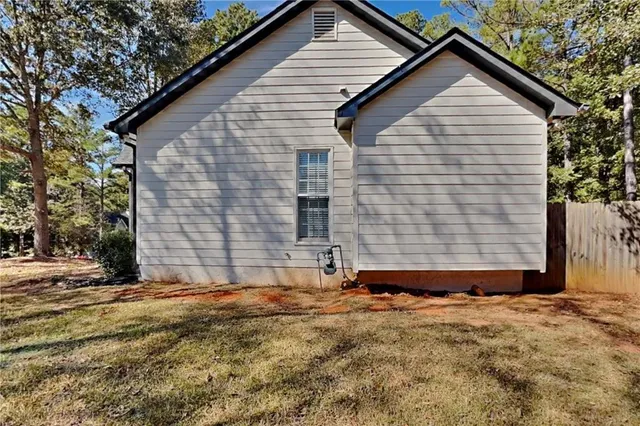 a view of wooden house with a yard and garage