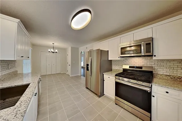 a kitchen with stainless steel appliances granite countertop a stove a refrigerator and a microwave