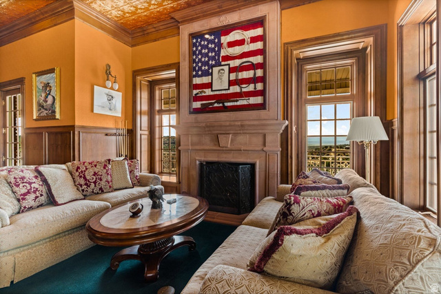 5615 East Eight Mile Gap Road Kanab, UT 84741 - Photo 36 of 81 Living area featuring an ornate ceiling, a fireplace, a wainscoted wall, and ornamental molding