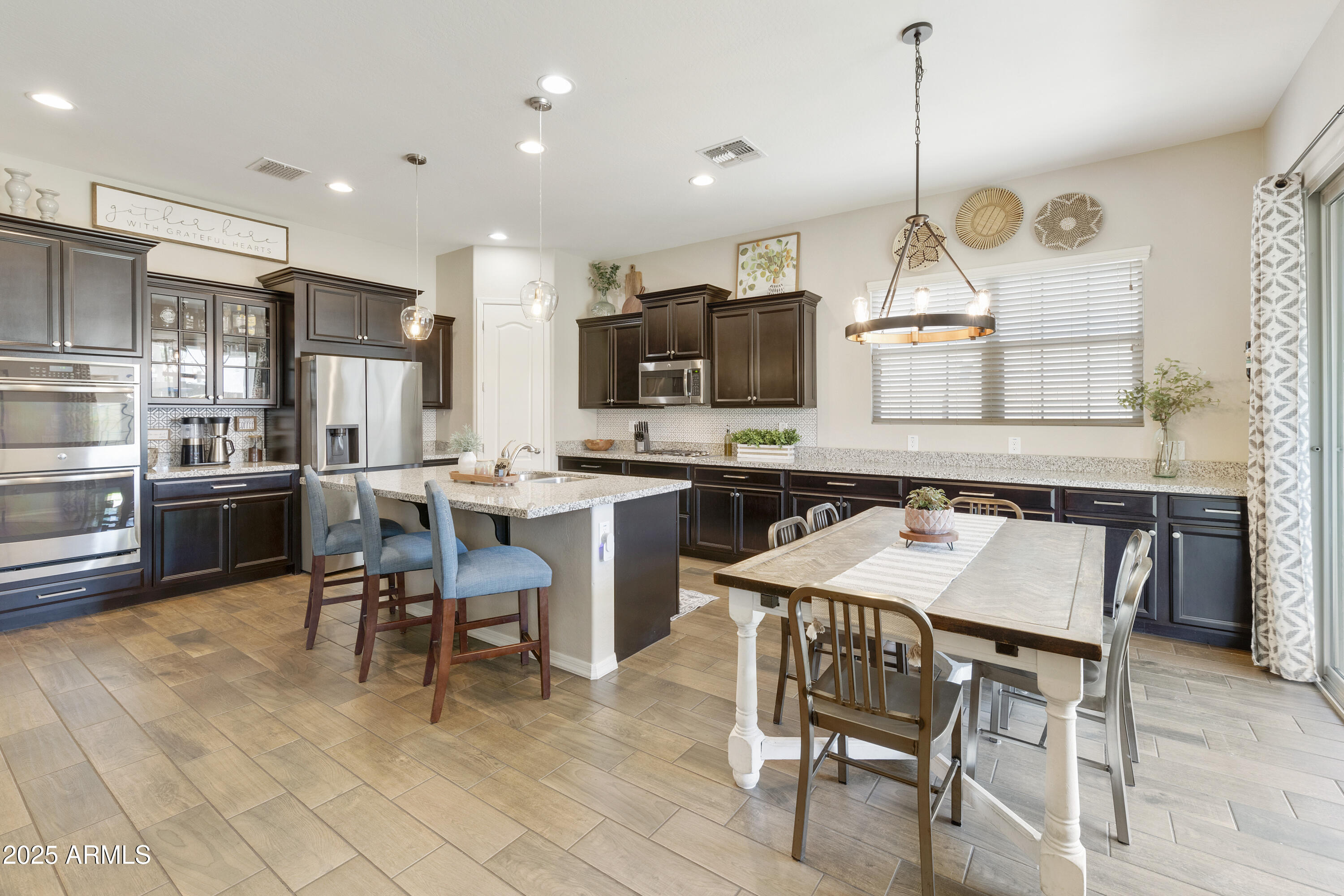 1517 West Redondo Drive Gilbert, AZ 85233 - Photo 1 of 55 a kitchen with stainless steel appliances kitchen island granite countertop a table chairs sink and cabinets