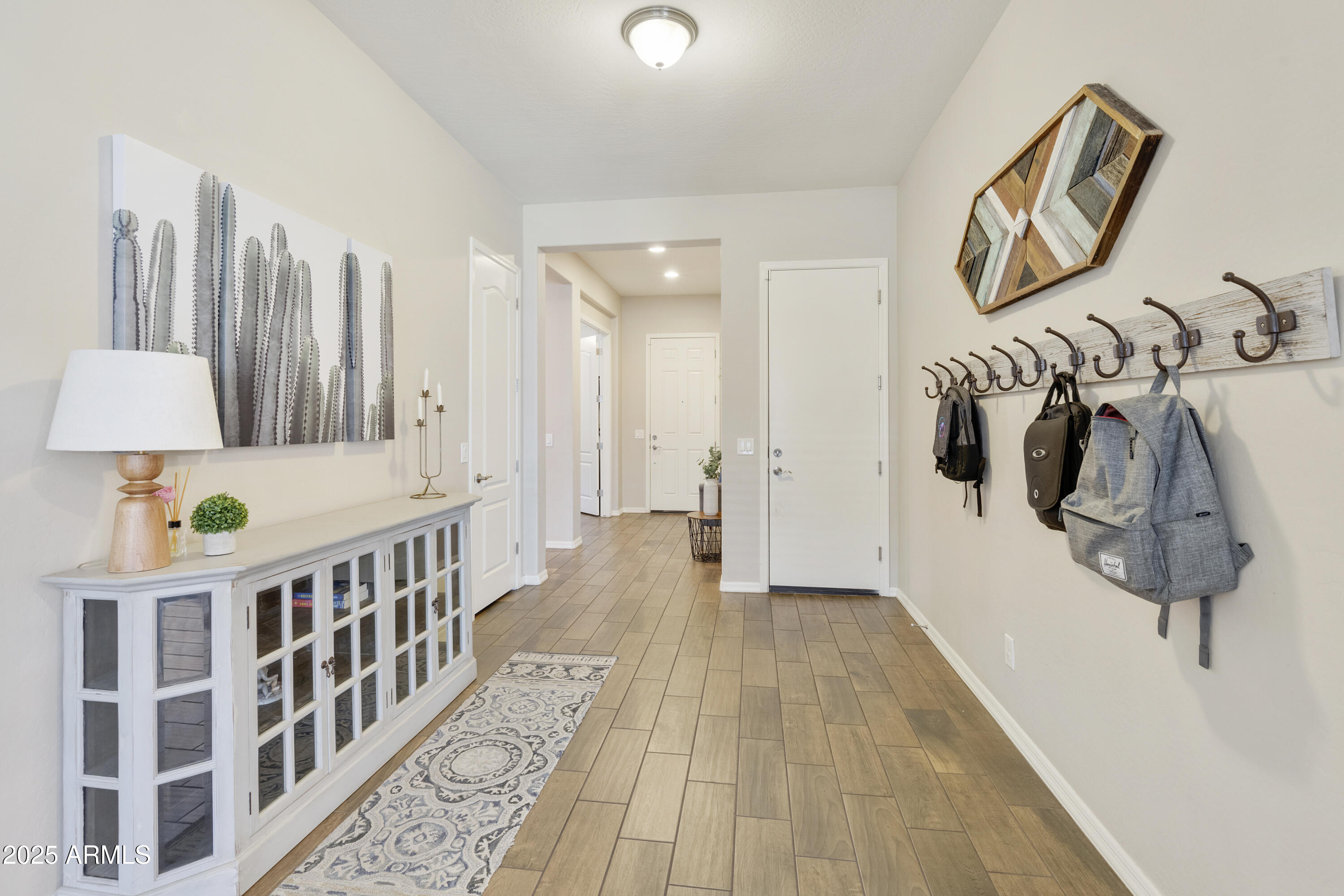 1517 West Redondo Drive Gilbert, AZ 85233 - Photo 17 of 55 a hallway with a white couches a table and a potted plant