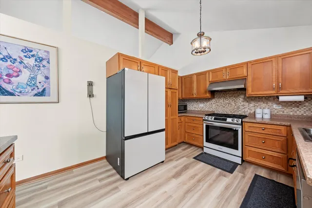 a kitchen with stainless steel appliances granite countertop a refrigerator and a stove top oven