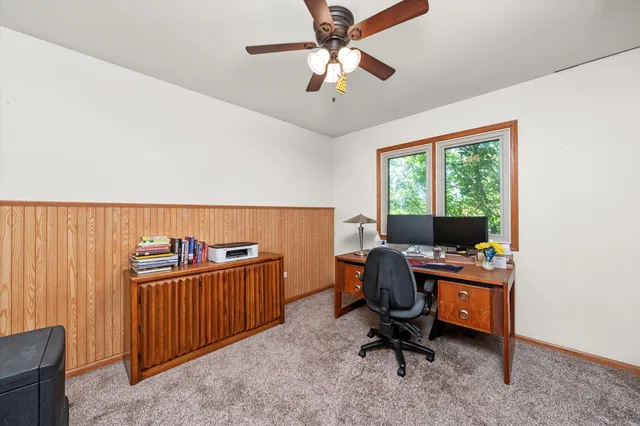 a view of a workspace with furniture and a window