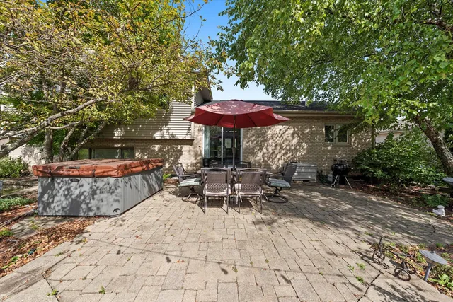 a view of a patio with table and chairs under an umbrella