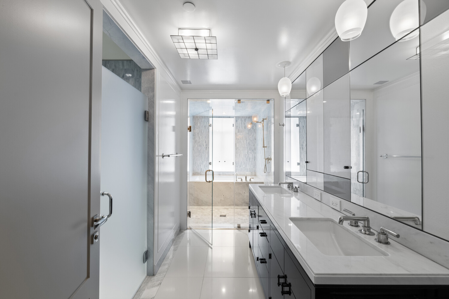 21 East 61st Street, Unit 8F Manhattan, NY 10065 - Photo 12 of 23 a large bathroom with a double vanity sink a mirror and a shower