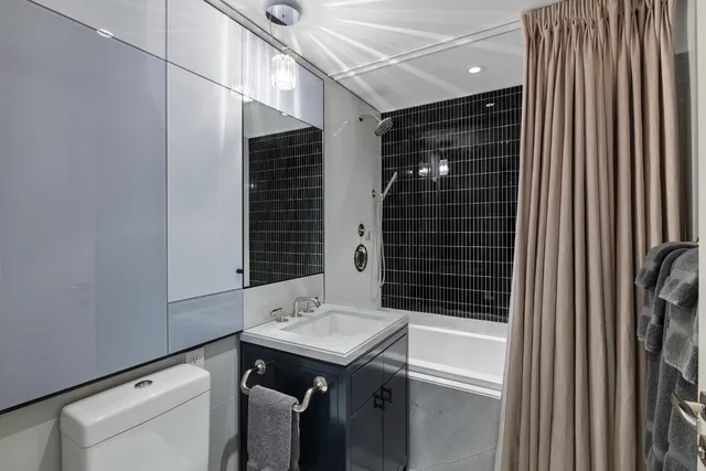 a bedroom with a large bed couch and windows