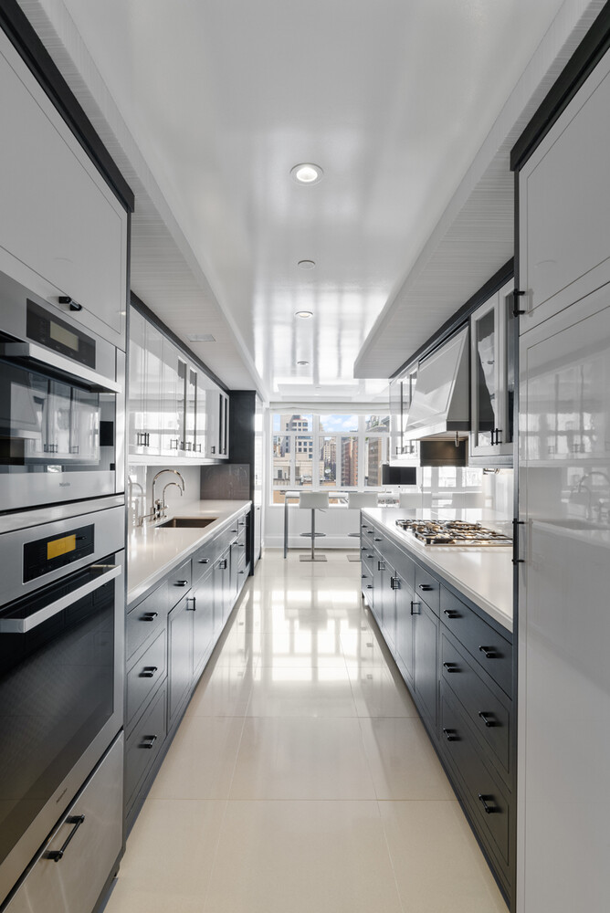 21 East 61st Street, Unit 8F Manhattan, NY 10065 - Photo 8 of 23 a large kitchen with stainless steel appliances and a sink