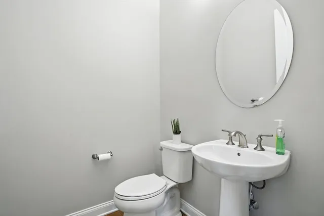 a bathroom with a sink a toilet and a mirror