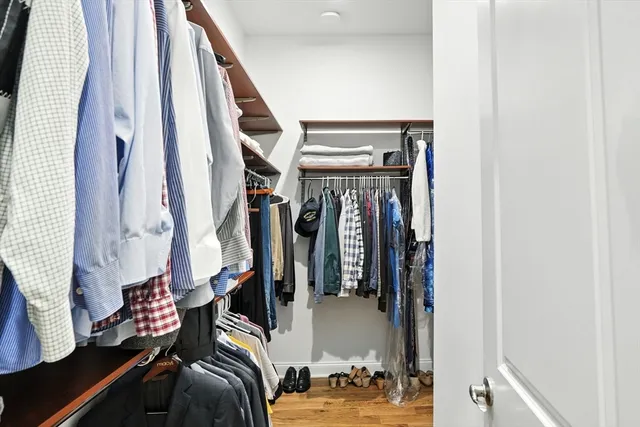a view of walk in closet with clothes and shoes