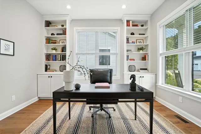 a view of a workspace with furniture and a window