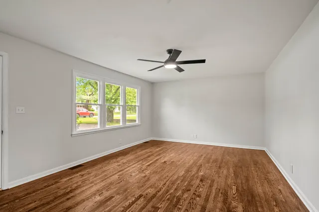 a view of a room with wooden floor and a window