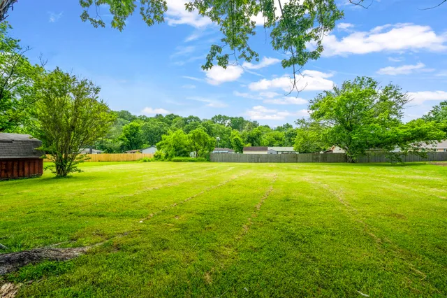 a view of yard with swimming pool and green space